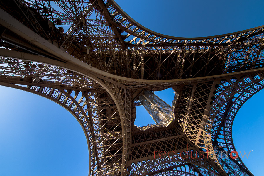 Photograph of the Eiffel Tower from underneath the eastern span. La Tour Eiffel (The Eiffel Tower) Paris France