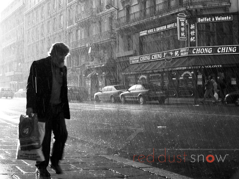 Paris Rain, a man walks along Rue du 8 Mai 1945 during a spring rain shower, near Gare de l'Est (East Station) in Paris