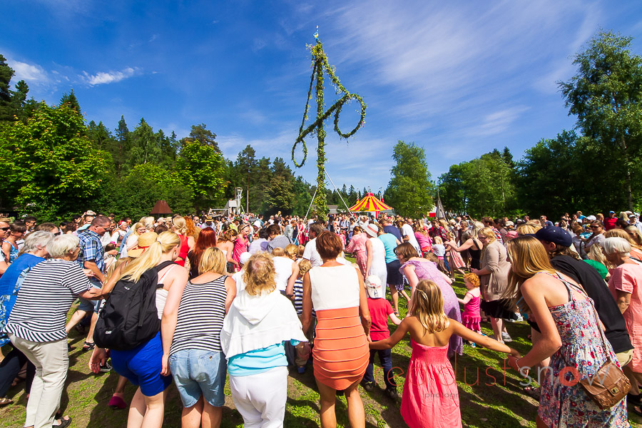 Dancing around the Midsommarstången (Midsummer Maypole) during Midsommar celebrations at Norra Berget, in Sundsvall, Sweden